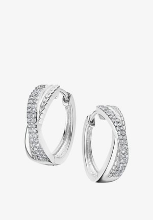 Les boucles d'oreilles en argent en forme de créoles présentent un design torsadé, avec un côté orné de petits cristaux transparents, offrant une texture polie et un éclat réfléchissant.