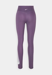 Fioletowe legginsy wykonane z elastycznego materiału, z wysokim stanem i białym logo Nike na dolnej lewej stronie.