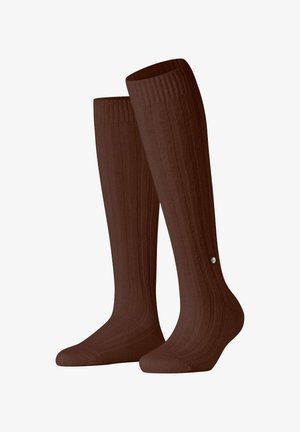 Chaussettes marron montantes avec une texture côtelée et un petit logo au niveau de la cheville. Fabriquées à partir d'un matériau lisse et extensible.