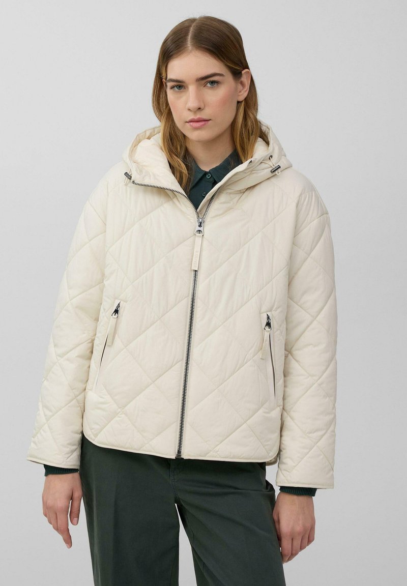 Gepolsterte, cremefarbene Pufferjacke mit Kapuze, ausgestattet mit einem Reißverschluss auf der Vorderseite, Seitentaschen und einem leicht übergroßen Schnitt. Glatte Textur und minimalistisches Design.