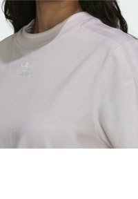 Jasnofioletowa bawełniana bluza z okrągłym dekoltem, zdobiona haftowanym logo. Paskowe boki w nieco jaśniejszym odcieniu dodają subtelnego detalu.