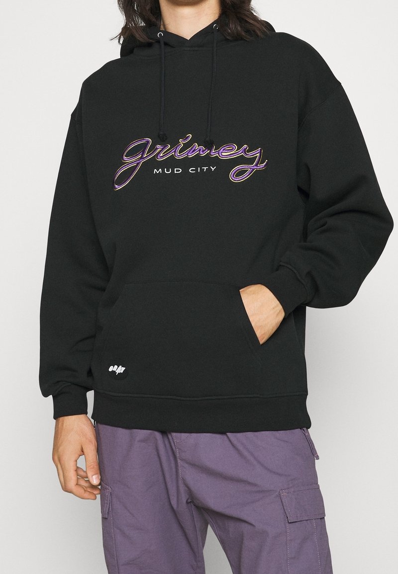 Černá mikina s kapucí, která má grafický textový design s nápisy "grimey" a "MUD CITY" v mnoha barvách vyšitými. Obsahuje přední kapsu a nastavitelnou kapuci.
