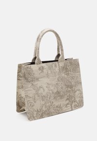 Beige schoudertas van textiel met een subtiel palmbladerenpatroon. Hij heeft twee stevige, ronde handvaten en een open bovenzijde.