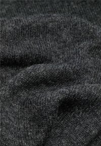 Tejido de punto gris oscuro con una superficie suave y texturizada, que presenta una mezcla de fibras. Muestra pliegues suaves y sutiles variaciones de tono.