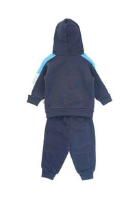 Survêtement bleu marine en tissu doux avec capuche, accents contrastants bleu clair aux épaules et poignets côtelés aux manches et aux chevilles.