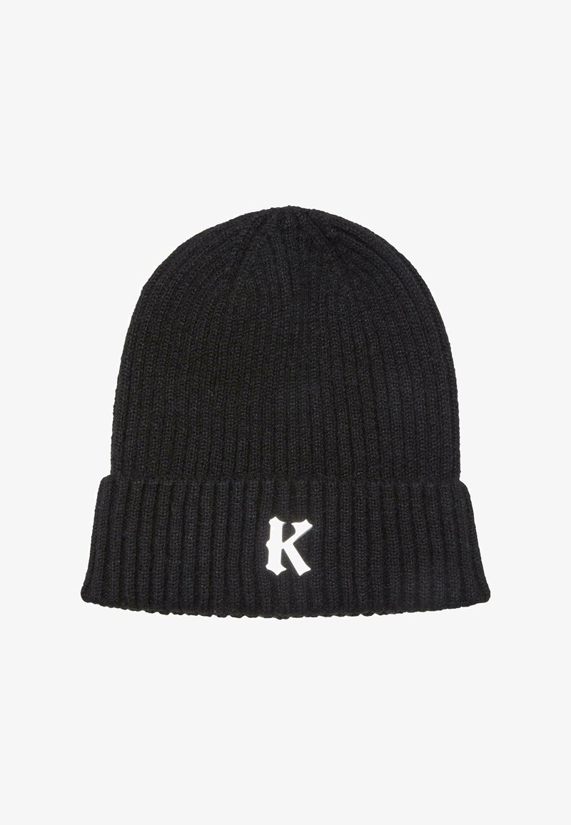 Črna pletena kapa z rebrastim vzorcem in prepognjenim robom; na sprednji strani je izvezeno belo črko "K". Mehka tekstura, prilegajoča se zasnova.