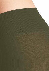 Olivgrüne, gerippte Strumpfhose mit transparentem Bereich im unteren Teil und einem breiten, glatten Bund für Komfort und Passform.