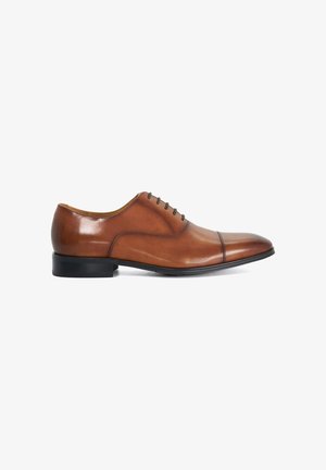 Chaussure habillée Oxford en cuir marron avec semelle noire et laçage fermé, finition polie et détail bout golf, vue de profil.