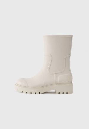 Weißer Gummi-Stiefelette mit runder Zehenpartie, strukturiertem Profil, dezenten Seitenverzierungen und Logo an der Ferse. Stilvolles und funktionales Design.
