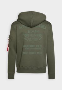 Felpa verde oliva con una grande stampa sul retro caratterizzata da grafiche ispirate all'ambiente militare, inclusa un'emblema a forma di piccone e una tasca laterale con hardware rosso.