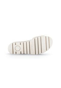 Suola di scarpa in gomma beige con una superficie testurizzata, caratterizzata da scanalature orizzontali e un logo circolare impresso. Progettata per trazione e durata.