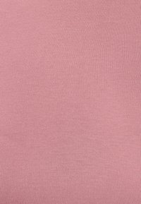 Tessuto a coste in morbido rosa, con una superficie texturizzata e fini linee verticali, flessibile e leggermente elasticizzato. Nessun motivo o dettaglio visibile.