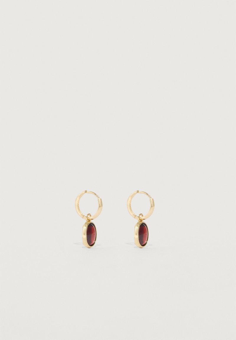 Aukso žiedinės auskarai, turintys giliai raudoną ovalo formos pakabuką, sklandžiu paviršiumi ir poliesteriu. Paprastas dizainas su klasikinėmis bruožais.