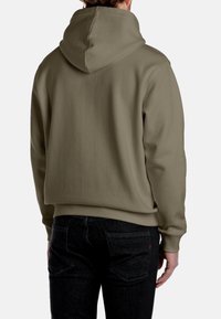 Hanorac verde măsliniu cu buzunar tip cangur, manșete ribbate și glugă cu șnur, purtat cu blugi negri din denim. Textura materialului este netedă.
