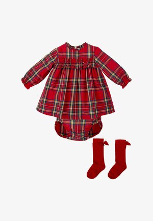Robe écossaise rouge à manches longues et encolure froncée, assortie à des culottes rouges et des chaussettes montantes avec des nœuds. Matière en coton.
