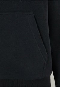 Felpa nera con tasca a marsupio, realizzata in morbido tessuto di cotone, con polsini e orlo a costine per un look aderente.