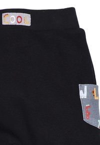 Zwarte katoenen joggers met een gestructureerde tailleband waarop "COOL" in kleurrijke letters staat, en een zijzak met speelse letterontwerpen.