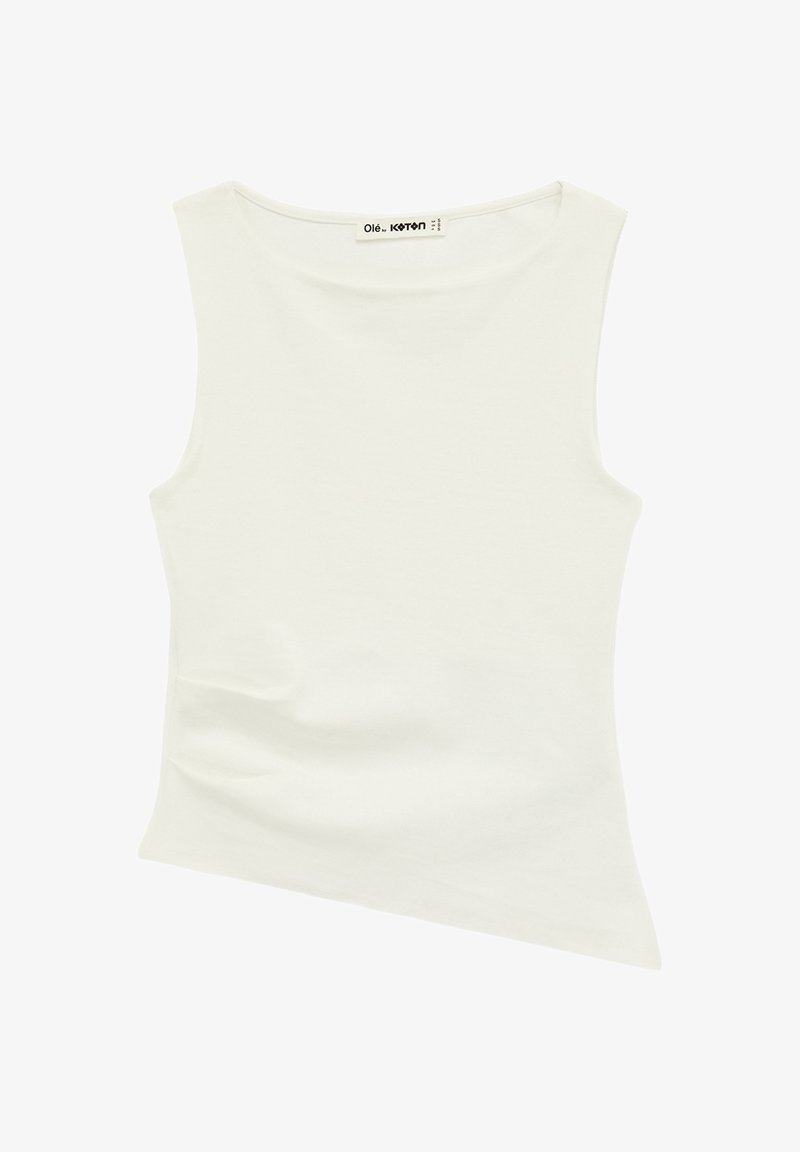 Haut blanc sans manches avec ourlet asymétrique, encolure bateau et étiquette de marque cousue à l'intérieur de l'encolure.