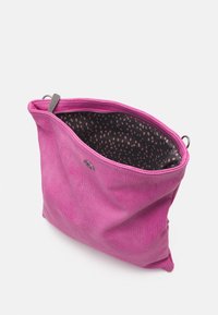 Borsa in pelle rosa con superficie texturizzata, chiusura a zip e un interno nero a motivi con punti rosa. Design compatto e alla moda.