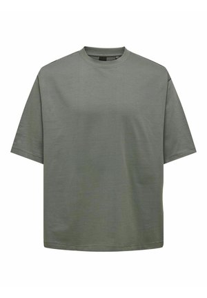 T-shirt surdimensionné vert olive en tissu doux. Il présente un col rond et des manches courtes, avec un design simple et épuré sans motifs.