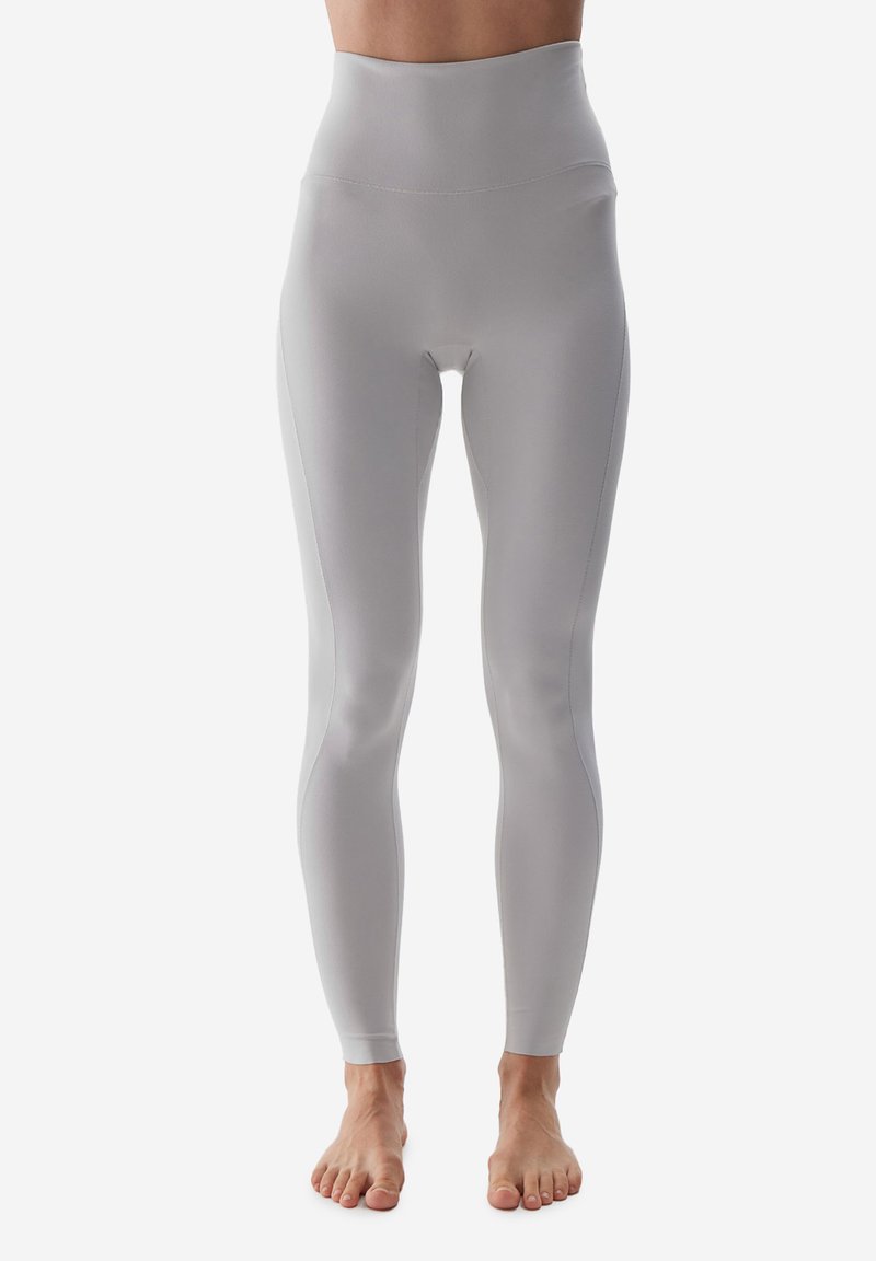 Vysoké, světle šedé legíny vyrobené z hladké, elastické tkaniny s jemnými bočními švy a elegantním, těsným střihem.