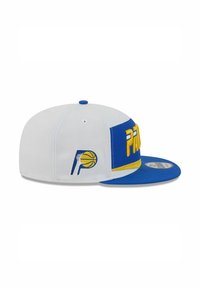 Cappellino da baseball bianco con visiera blu. Presenta testo ricamato giallo e blu e un logo con una palla da basket. Design con visiera piatta.