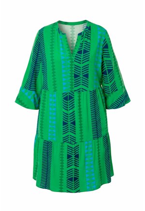Groene jurk tot op de knie met blauwe en donkergroene geometrische verticale strepen, driekwart klokmouwen en een kraagloze V-hals.