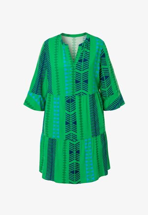 Groene jurk tot op de knie met blauwe en donkergroene geometrische verticale strepen, driekwart klokmouwen en een kraagloze V-hals.
