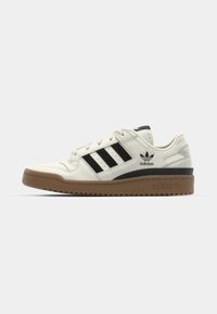 Bijele kožne tenisice s crnim prugama, gumeni potplat i podstavljena ovratnik. Sadrži Adidas logo na jeziku i sa strane. Klasičan dizajn u niskom izdanju.
