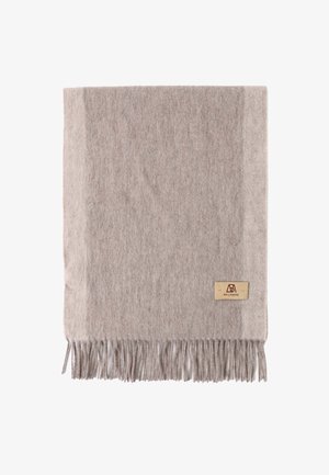 Light brown wool blanket with fringed edges. Features a textured surface and a small branded tag in the bottom right corner.