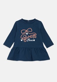 Μπλε σκούρο φόρεμα με μακριά μανίκια και φουσκωτή φούστα, με ροζ κεντημένο κείμενο που γράφει "Guess Love" και μικρές καρδιές. Απαλό βαμβακερό ύφασμα.