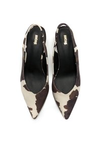 Zapatos slingback de punta afilada con estampado de piel de vaca en tonos marrón y crema, con un interior negro elegante y recortes laterales.