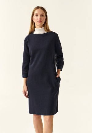 Navy blue dress with a round neck, three-quarter sleeves, side pockets, and a relaxed fit; made of a smooth, stretchy fabric.