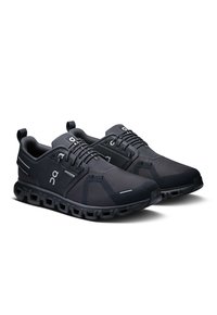 Baskets noires de sport avec une tige en maille respirante, bout arrondi, lacets élastiques et une semelle rembourrée dotée d'éléments uniques en forme de nuage.