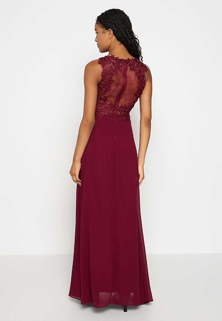 Burgundowa wieczorowa sukienka z przezroczystym koronkowym tyłem, kwiatowym haftem na ramionach i zwiewną spódnicą, z zapięciem na zamek z tyłu.