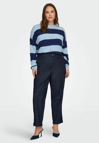 Blue and navy striped long-sleeve shirt, dark denim high-waisted pants, roll-up cuffs, and navy pointed-toe heels. Simple design with soft texture.