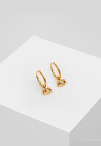 Guld hoops øreringe med et lille ø-motiv. Har en opaliserende perle og intrikat detaljer ved bunden. Glat, skinnende finish.