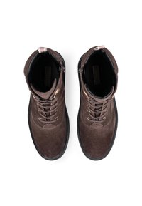 Botine din suede maro cu vârf rotunjit, talpă din cauciuc negru, șireturi în față și fermoare pe laterale. Caracterizate prin accesorii din metal cu nuanță de aur.