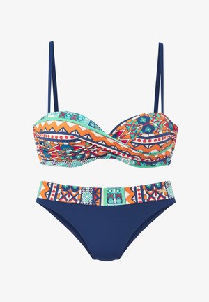 Two-piece bikini with geometric and tribal patterns in orange, teal, navy blue, and white; top has adjustable navy straps and ruched detail.