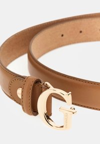 Tan leather belt with a slim design, featuring a shiny gold-tone 'G' buckle and a small brand tag. Smooth texture and multiple size holes.