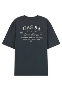 T-shirt in cotone grigio scuro con stampa grafica in testo bianco, maniche corte e scollatura rotonda. Il testo include dettagli del marchio e del prodotto.