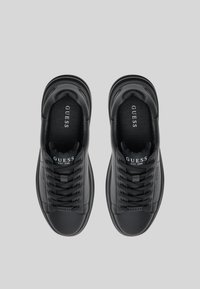 Sorte joggesko laget av glatt skinn med rund tå, kontrastfargede lisser og preget logo på tungen, med polstret krage for komfort.