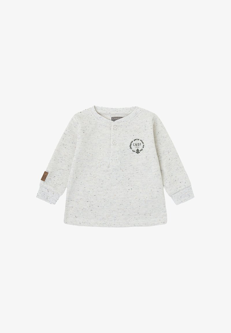 Camiseta de manga larga en color blanco roto para niño pequeño, con patrón salpicado, dos botones en el cuello, pequeño estampado circular negro en el pecho y detalles en los puños.