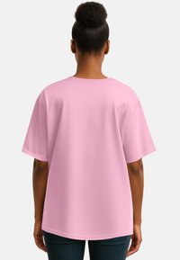 T-shirt di cotone rosa con maniche corte e vestibilità rilassata. Texture liscia, scollo a girocollo e dettaglio a orlo curvo nella parte inferiore.