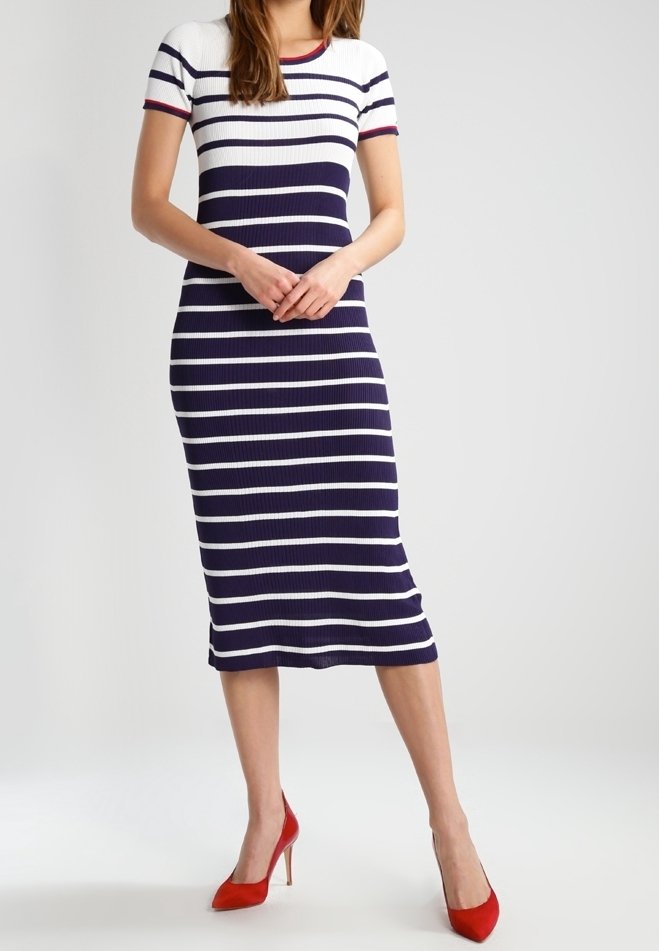 Robe midi rayée en bleu marine et blanc, texture côtelée, manches courtes, col rond avec des accents rouges, associée à des escarpins rouges.