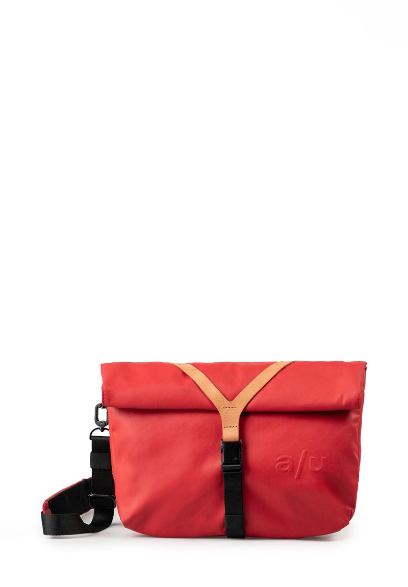 Borsa a tracolla rossa realizzata in tessuto resistente, con una parte superiore pieghevole, dettagli in pelle color cuoio e una tracolla nera regolabile con chiusura a fibbia.