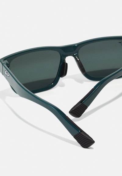 Green plastic sunglasses with dark grey lenses, featuring a smooth design and textured black rubber tips on the arms for grip.