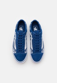 Niebieskie trampki z płótna z białymi akcentami, z paisleyowym wzorem po bokach i teksturowanym zamszowym noskiem. Zaprojektowane z płaskimi sznurówkami.