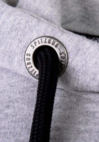 Grijze sweatshirtstof met een ronde metalen ooglet met de inscriptie "SPITZBUB". Zwarte trekkoord gaat door de ooglet.