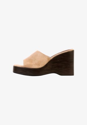 Mule beige de ante con punta abierta, tacón cuña alto de madera oscura y diseño sin cierre.